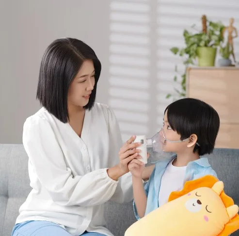Mẹ cầm máy xông dạng lưới Omron NE-U300 cho bé xông thuốc mũi họng nhẹ nhàng